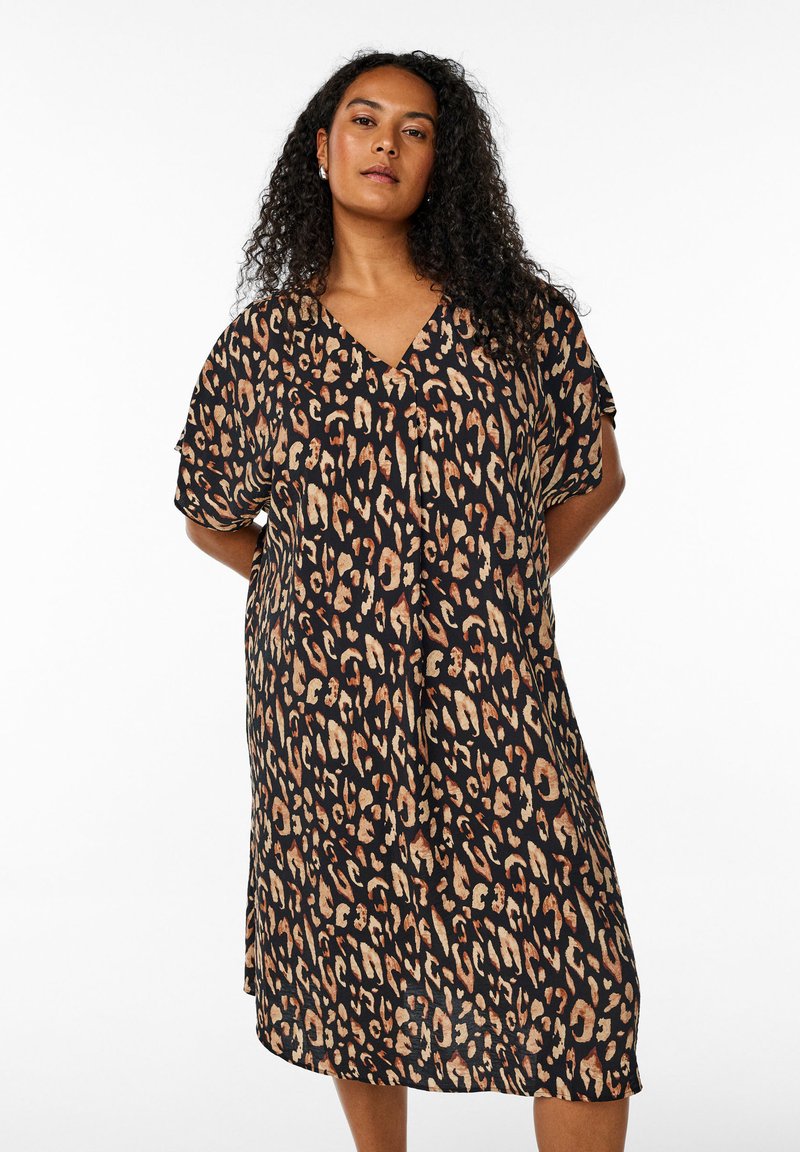 Robe imprimé léopard en noir, beige et marron. Décolleté en V, manches courtes, coupe ample, longueur genou, tissu doux avec une texture fluide.