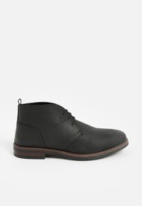 Schwarzer Chukka-Stiefel aus Leder mit glatter Textur, abgerundeter Spitze und dreilöchrigem Schnürdesign. Braune Kontrastnähte an der Sohle.