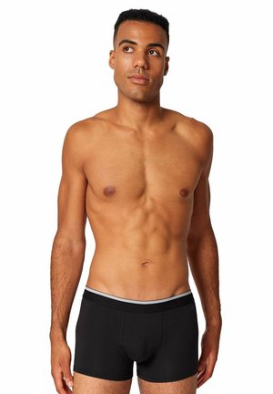 Zwarte boxer briefs met een zachte tailleband en een subtiele grijze accent, gemaakt van rekbaar materiaal. Het model heeft een slanke lichaamsbouw.