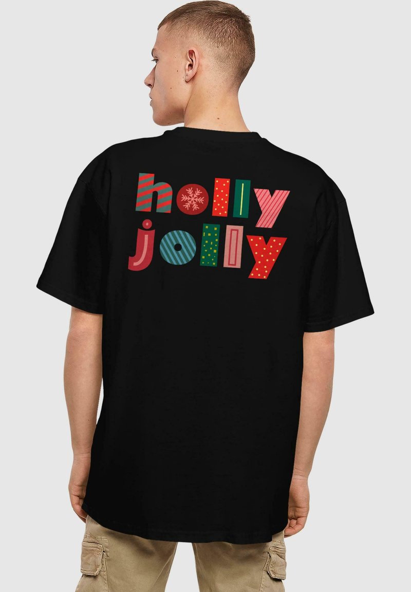 Sort t-shirt med teksten "holly jolly" i forskellige farverige, festlige mønstre og skrifttyper. Korte ærmer og afslappet pasform.