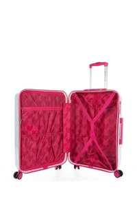 Maleta rígida con exterior blanco, cremallera y acentos en rosa, y un interior rosa brillante con patrones de corazones y compartimentos organizativos.