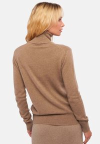 Brauner, taillierter Rollkragenpullover mit gerippten Bündchen und Saum. Weicher Stoff, ausgelegt für eine enge Passform. Ansicht von hinten.