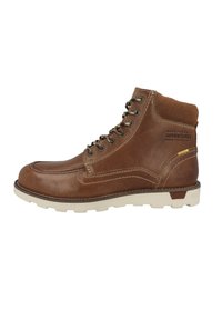 Bota de senderismo de cuero marrón con un cuello acolchado, ojales de metal, suela de goma blanca y costuras en contraste. El texto en el lateral dice "HECHA PARA AVENTURAS DIARIAS."