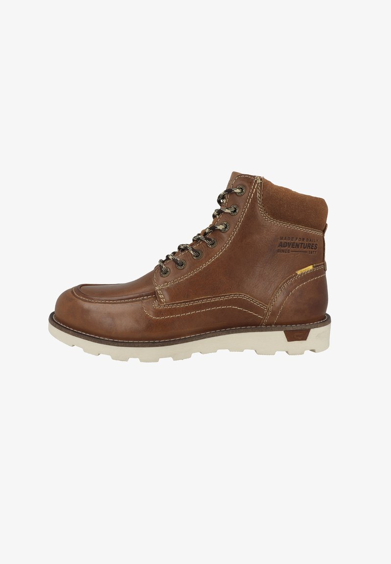 Bota de senderismo de cuero marrón con un cuello acolchado, ojales de metal, suela de goma blanca y costuras en contraste. El texto en el lateral dice "HECHA PARA AVENTURAS DIARIAS."