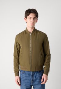 Olive green bomber jacket with a zip front, ribbed cuffs, side pockets, and contrast stripes along the sleeves. Smooth, lightweight material.