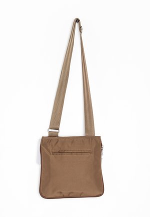Sac bandoulière carré marron avec sangle réglable et une poche zippée horizontale à l’avant, suspendu sur fond blanc.