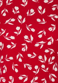 Röd tyg med ett vitt blommönster med små tulpanformer och blad, arrangerade över textilen i en enhetlig design.