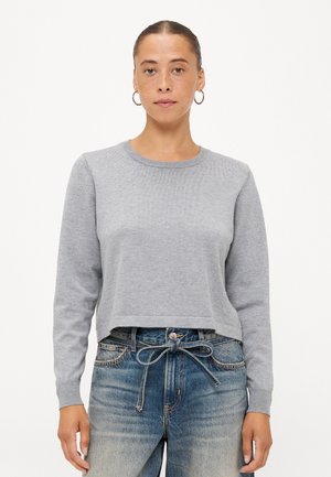Grå cropped genser med lange ermer, ribbestrikket halslinning og mansjetter. Myk tekstur; kombinert med høy midje blå jeans med knyttet belte.