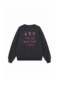 Schwarzer Hoodie mit pinken Kritzeleien und dem Text "Ich bin meine eigene Muse" sowie kleinerer Schrift darunter, zentriert auf der Rückseite.