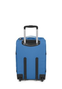 Blå handbagageväska med ett robust tygutsida, utfällbart handtag och fyra svarta hjul för rörlighet.