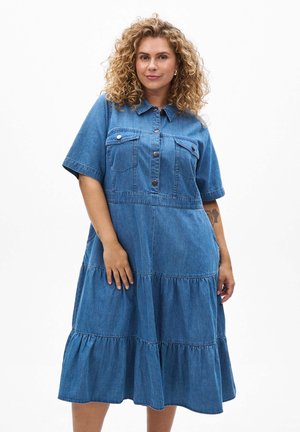 Denimjurk met een kraag, korte mouwen en twee borstzakken. Voorzien van een gelaagde volantzoom in een diepe blauwe wassing.