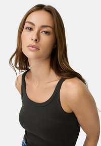 Sort tanktop lavet af blødt stof, med en rund halsudskæring og brede skulderstropper, tætsiddende design og rene syninger.