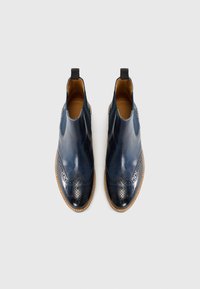 Bottines en cuir marine avec des détails de brogue, finition lisse, panneaux latéraux élastiques et semelle en caoutchouc beige.