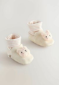 Bottines crème avec une texture douce et moelleuse, un revers à carreaux rose et blanc, et un détail en tricot avec un visage d'ours à l'avant.