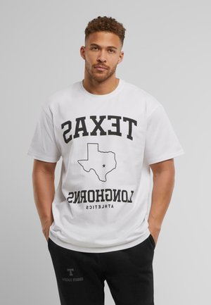 White cotton t-shirt featuring bold black text: "TEXAS" above a Texas outline, "LONGHORNS" below. Relaxed fit with short sleeves.