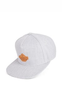 Cappello in tessuto grigio con visiera piatta, caratterizzato da un'etichetta in pelle marrone chiaro con la scritta "BLACKSKIES" sul davanti. Texture liscia e design minimalista.