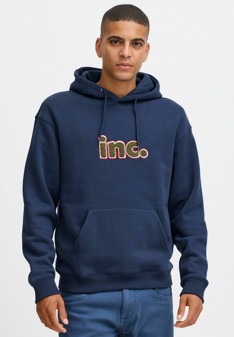 Felpa blu navy in morbido tessuto, con tasca frontale e cordini. Logo "inc." ricamato in multicolor.
