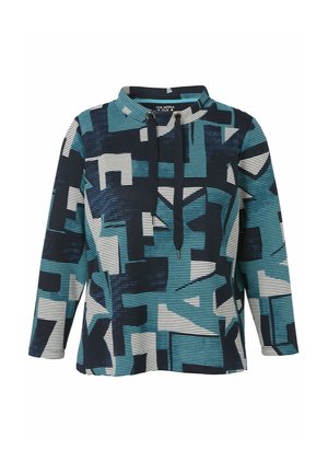 Langärmliger Pullover mit geometrischen Mustern in Blaugrün, Marineblau und Weiß sowie einem hohen Kragen mit schwarzen Kordeln.