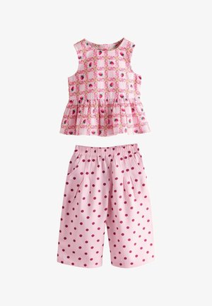 Top roz fără mâneci pentru copil mic, cu imprimeu cu căpșuni, și pantaloni scurți asortați roz, cu buline roz închise și talie elastică.