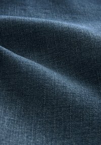 Denimstoff in Dunkelblau mit einer subtilen Textur und einem diagonalen Webmuster, das eine glatte Oberfläche und einen weichen Fall zeigt.