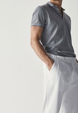 Gray short-sleeve polo shirt with a collar and three buttons, paired with white pleated trousers. Smooth fabric texture.