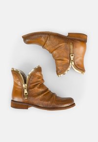 Botas tobilleras de cuero marrón con un diseño arrugado, que presentan cremalleras doradas y un patrón texturizado. Punta redondeada y tacón de madera bajo.
