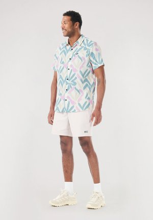 Short-sleeve button-up shirt with a blue, pink, and white floral pattern. Paired with white shorts and beige athletic shoes.