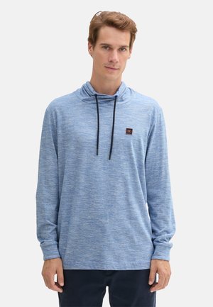 Langärmliger Hoodie in Hellblau, aus strukturiertem Stoff, mit einem Schalkragen und einem kleinen Logo-Patch auf der Brust. Dunkle Kordeln als Detail.