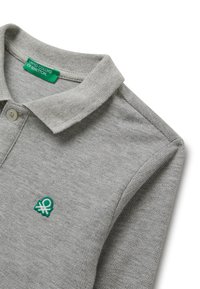 Hellgraues Poloshirt mit Kragen, weißem Knopf und kleinem, grünen, gestickten United Colors of Benetton-Logo auf der Brust.
