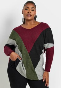 Maglione con scollo a V e pannelli bicolore in borgogna, verde, grigio e nero. Texture morbida, con maniche lunghe e tasche laterali.