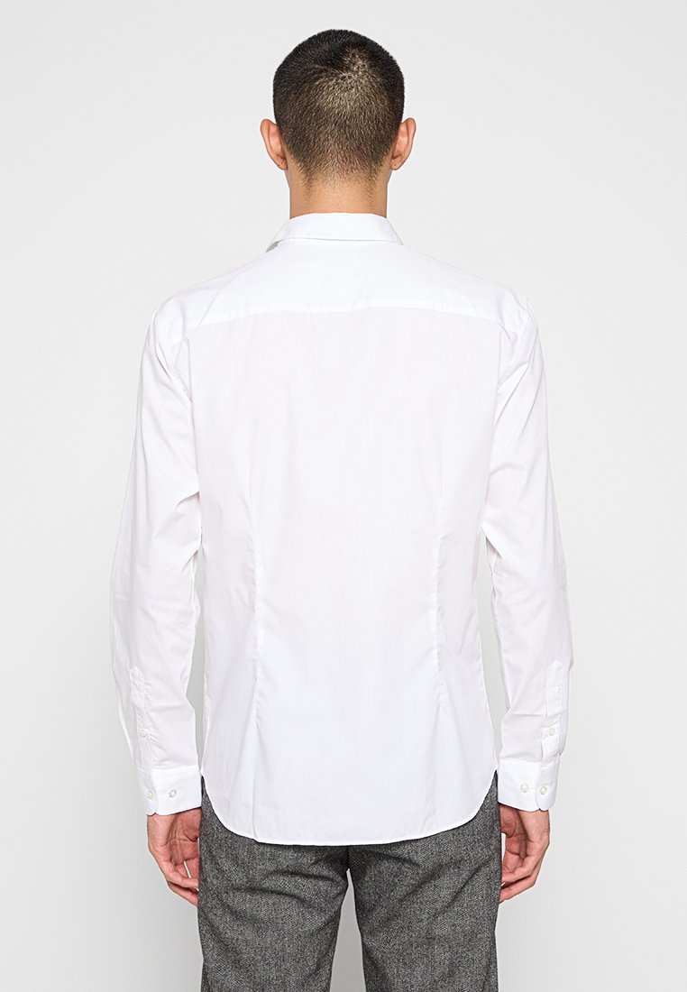 Witte blouse met lange mouwen en een standaardkraag, met een subtiele glans, knoopmanchetten en een getailleerd ontwerp. Gladde katoenen stof.