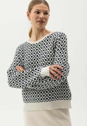 Black and white patterned knit sweater with a relaxed fit, featuring ribbed cuffs and hem. The design includes geometric shapes.