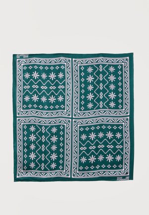 Carré vert foncé avec des motifs géométriques blancs et en forme d'étoile divisés en quatre sections égales.