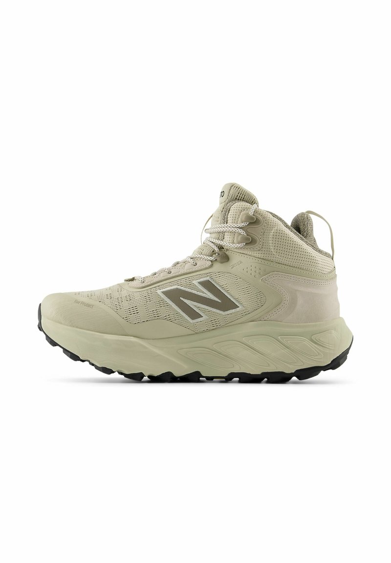 Zapatilla deportiva alta color beige con parte superior de malla transpirable, cuello acolchado y suela de goma, destacando un prominente logo "N" en color plata.