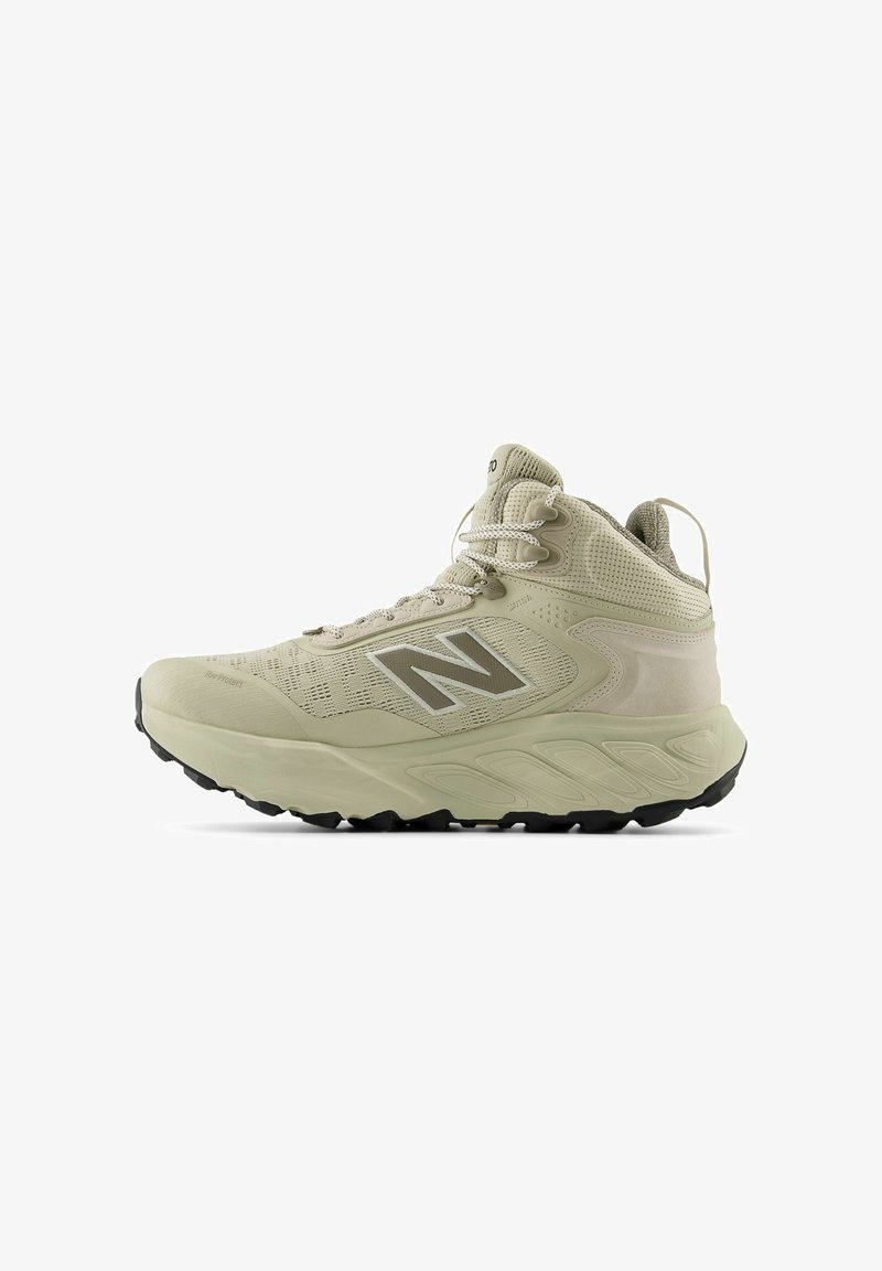 Zapatilla deportiva alta color beige con parte superior de malla transpirable, cuello acolchado y suela de goma, destacando un prominente logo "N" en color plata.