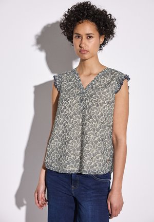Blouse légère à motif avec un décolleté en V et des manches courtes. Présente un design floral en couleurs crème et bleu marine. Texture douce.