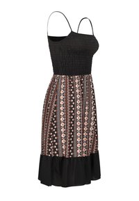 Robe noire à motifs avec fines bretelles, corsage smocké et jupe évasée ornée d'accents floraux et d'un ourlet à volants.