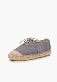 Gray canvas espadrille with a rounded toe, jute-woven sole, and brown lace detail. The upper features stitching accents and textured sections.