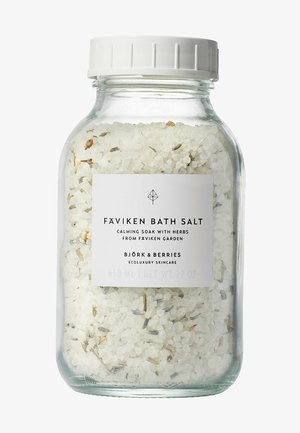 Glasbehälter gefüllt mit weißen Badesalzen, die mit Kräutern vermischt sind. Verfügt über ein weißes Etikett mit schwarzem Text und einen Schraubdeckel. Fassungsvermögen von 630 ml.