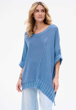 Blauer Strickpullover mit einer lockeren Passform, oversized Design, gerippten Bündchen und einer diagonalen Naht mit einer Reihe von Lochdetails.