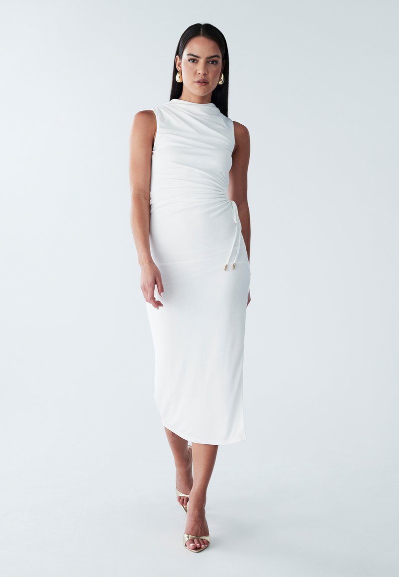 Robe midi blanche sans manches avec une silhouette ajustée, un tissu drapé et un détail de nœud sur le côté. Texture lisse, éclat subtil et longueur jusqu'aux chevilles.