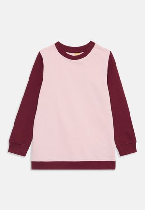 Langermet genser med rund hals, lys rosa kropp og mørk burgunder ermer, krage og nederkant, lagt flatt på hvit bakgrunn.