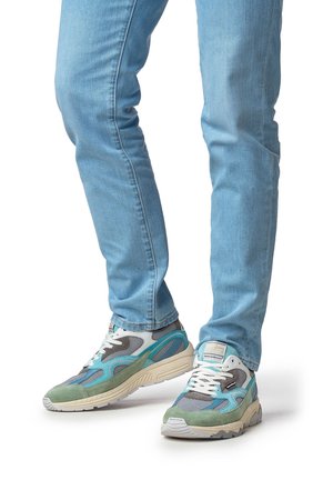 Zapatillas multicolor con materiales de malla y ante. Detalles en gris, azul verdoso y verde. Suela gruesa y patrones texturizados en la parte superior.