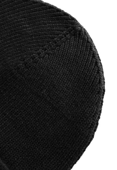 Crna pletena kapa s rebrastom teksturom i bešavnom dizajnom, s zaobljenim vrhom i mekanim, fleksibilnim prianjanjem.