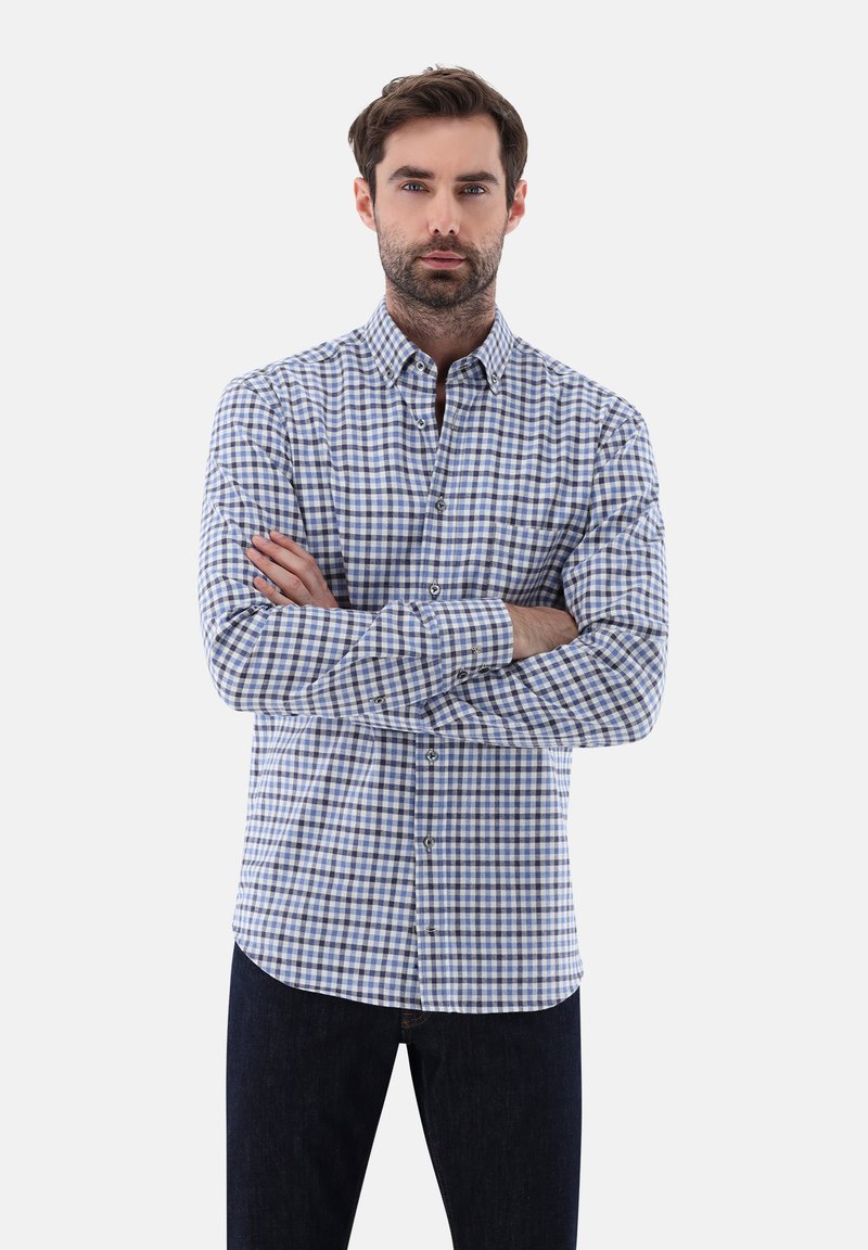 Herren Hemd mit langen Ärmeln im blau-weißen Karomuster. Baumwollstoff, Kentkragen, Brusttasche, gerader Saum, kombiniert mit dunklen Jeans.