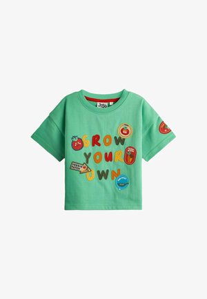 T-shirt vert manches courtes pour enfant avec des lettres colorées "Grow Your Own" et diverses écussons sur le thème des légumes et du jardin.
