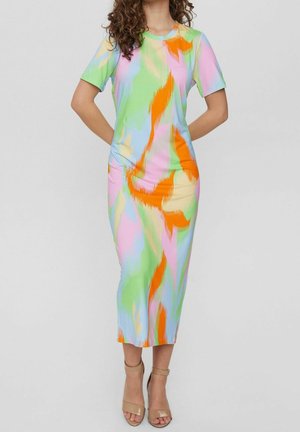 Frau trägt ein figurbetontes Midi-Kleid mit kurzen Ärmeln, das ein abstraktes Muster in Pastellgrün, Pink, Blau, Beige und Orange zeigt, sowie beige Sandalen mit hohen Absätzen.