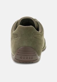 Zielone zamszowe sneakersy z zaokrąglonym obcasem, teksturowaną brązową podeszwą oraz wytłoczonym logo marki. Posiadają wyściełany kołnierz dla komfortu.