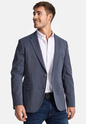 Dark blue blazer made of textured fabric, featuring two buttons, two front pockets, and tailored fit, worn over a white shirt.