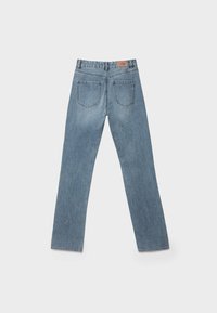 Světlé modré džíny s rovnými nohavicemi. Mezi charakteristické rysy patří zadní kapsy, poutka na opasek a kožená nášivka na pase.